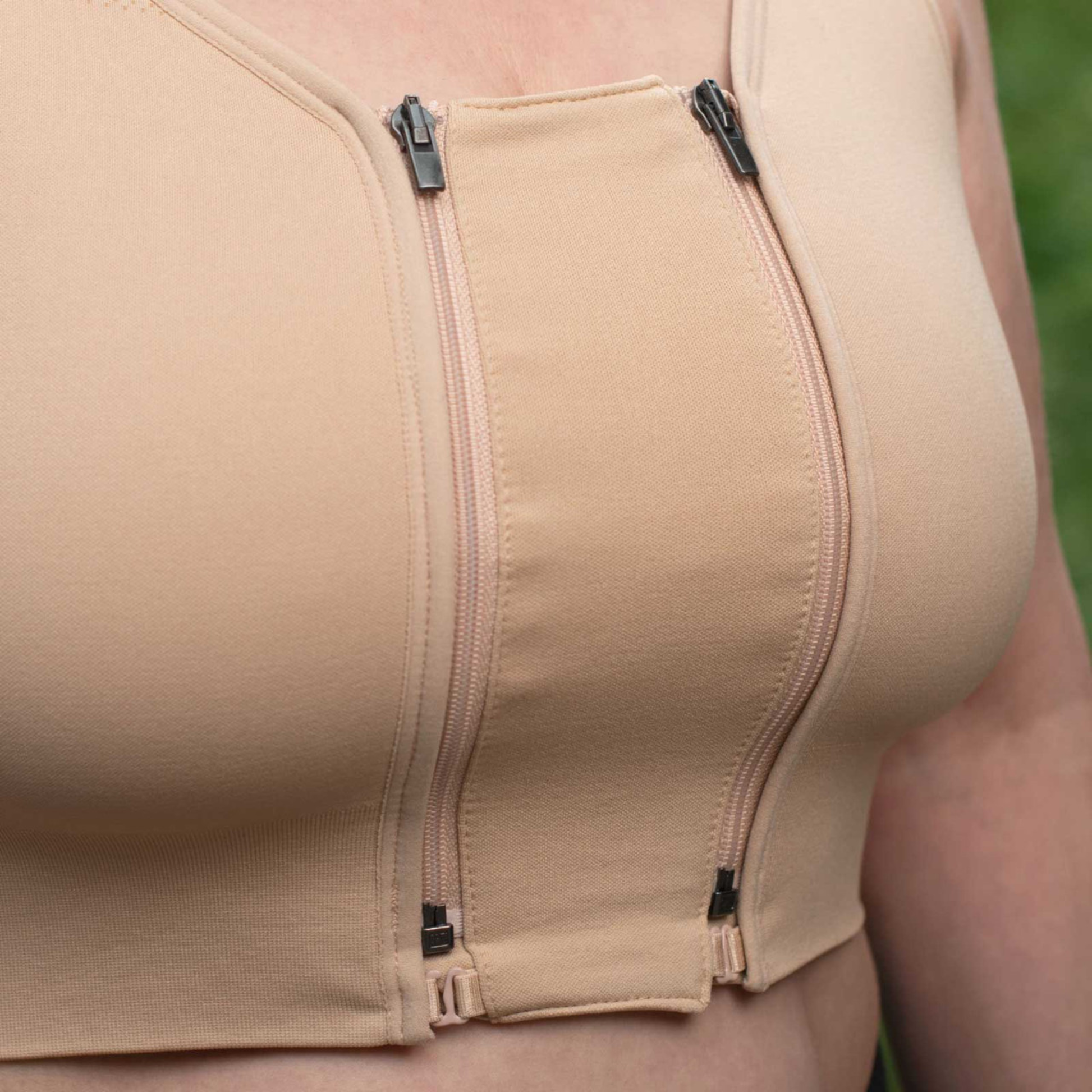 Close-up of Prairie Wear HuggerPRIMA compression bra front zip closures with extender added, adjustable padded straps, beige.